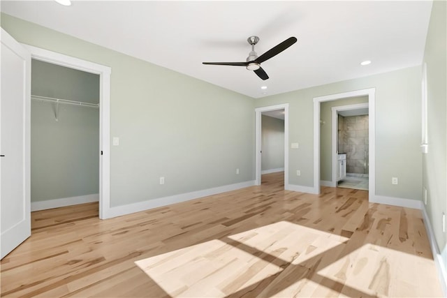 unfurnished bedroom with ceiling fan, a closet, connected bathroom, and light hardwood / wood-style floors