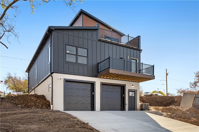 view of front of home with central AC unit, a balcony, and a garage