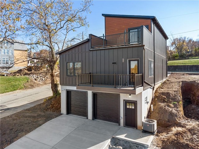 view of front of home with central AC, a balcony, and a garage