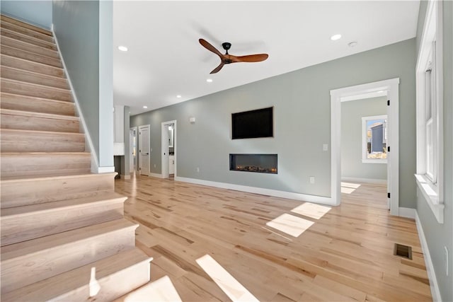 unfurnished living room with ceiling fan and light hardwood / wood-style flooring