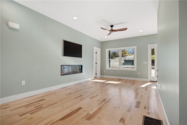 unfurnished living room with ceiling fan and light hardwood / wood-style flooring