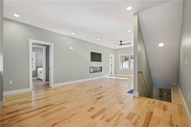 unfurnished living room with light wood-type flooring and ceiling fan