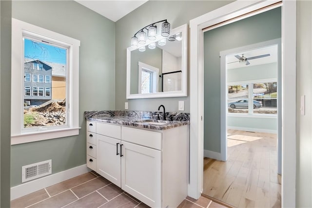 bathroom with ceiling fan, plenty of natural light, and vanity