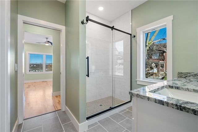 bathroom with ceiling fan, vanity, an enclosed shower, and tile patterned floors