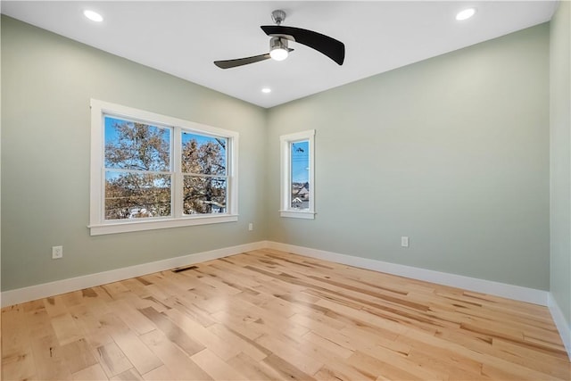 spare room featuring light hardwood / wood-style floors, a wealth of natural light, and ceiling fan