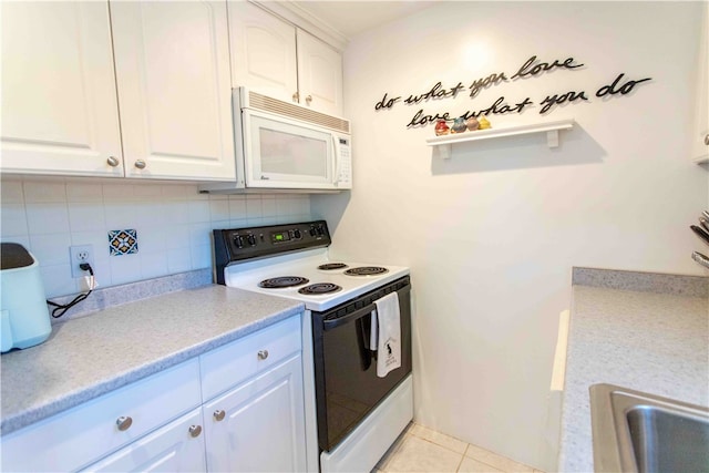 kitchen with decorative backsplash, white appliances, light tile patterned floors, and white cabinets