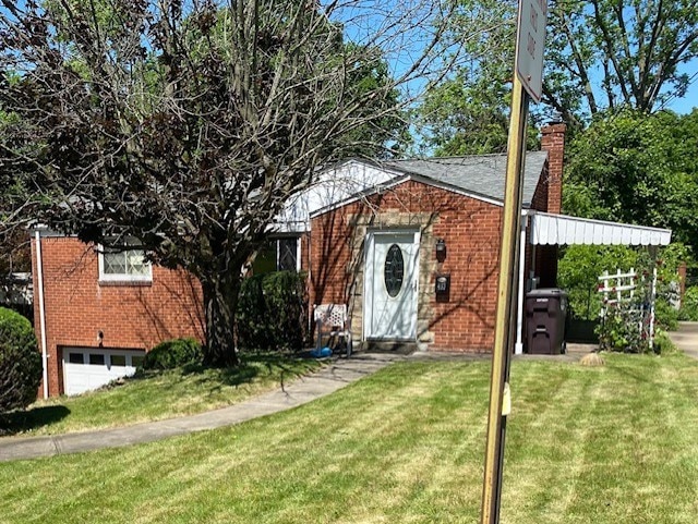 view of front of home with a garage and a front lawn