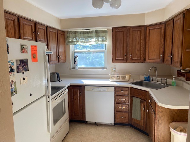 kitchen featuring sink, range hood, and white appliances