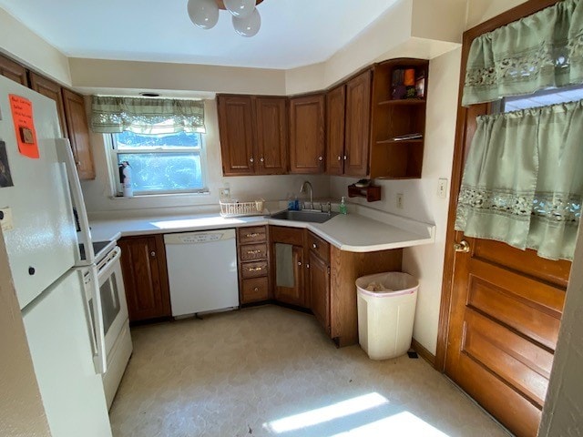 kitchen with sink, light colored carpet, and white appliances