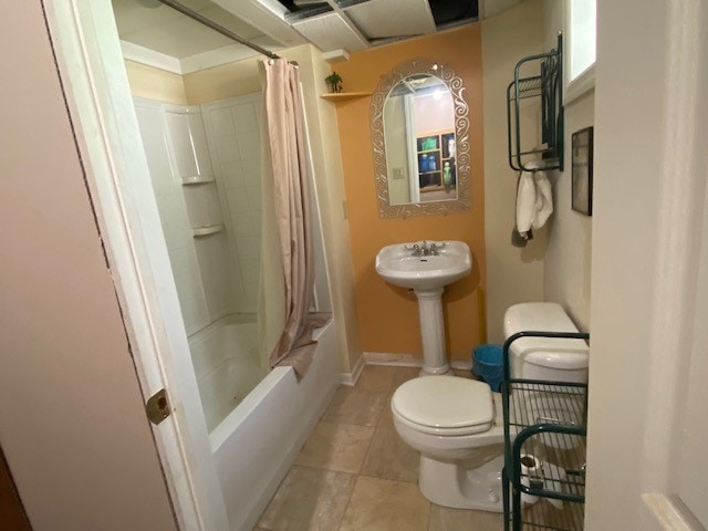 bathroom featuring toilet, shower / bath combo, and tile patterned flooring