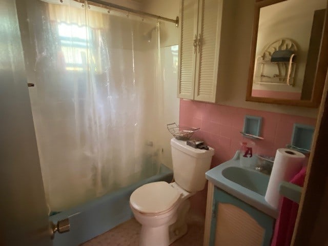 full bathroom featuring shower / tub combo, tasteful backsplash, tile walls, toilet, and vanity