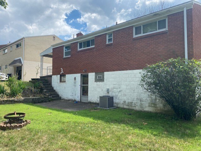 back of property with a yard and cooling unit