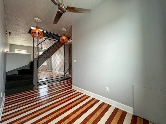 interior space with a textured ceiling and ceiling fan