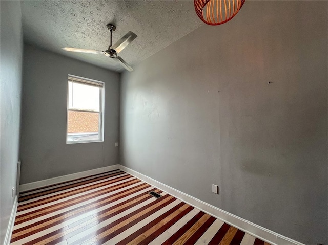 spare room with a textured ceiling, vaulted ceiling, and ceiling fan