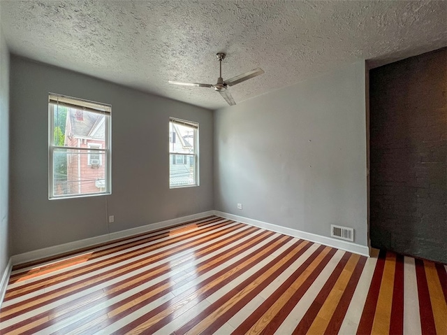 spare room with a textured ceiling, ceiling fan, and hardwood / wood-style floors