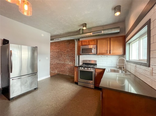 kitchen featuring brick wall, appliances with stainless steel finishes, a textured ceiling, and sink