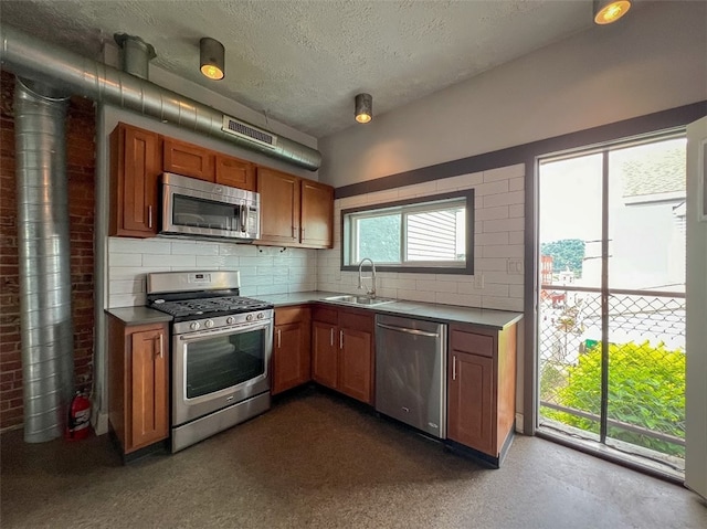 kitchen featuring appliances with stainless steel finishes, backsplash, and sink