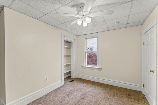 unfurnished bedroom featuring carpet floors, a paneled ceiling, and ceiling fan