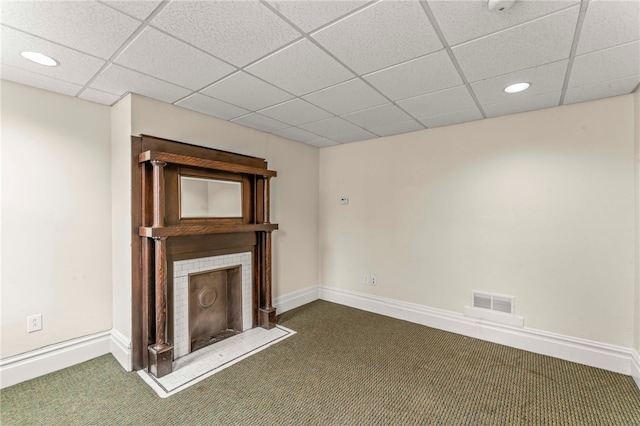 unfurnished living room featuring dark carpet and a paneled ceiling