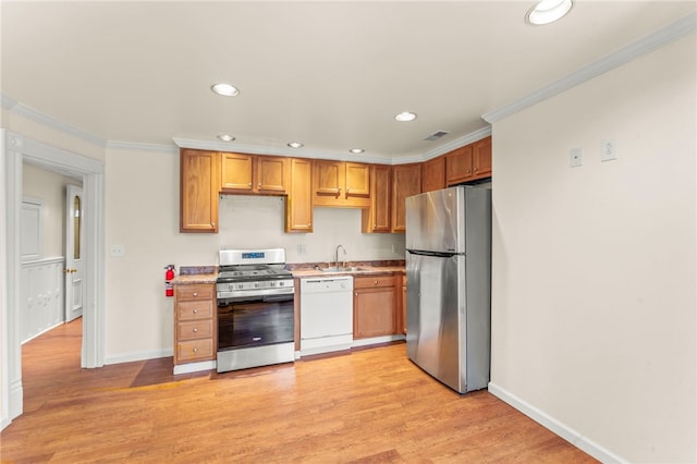 kitchen with sink, crown molding, light wood-type flooring, and stainless steel appliances