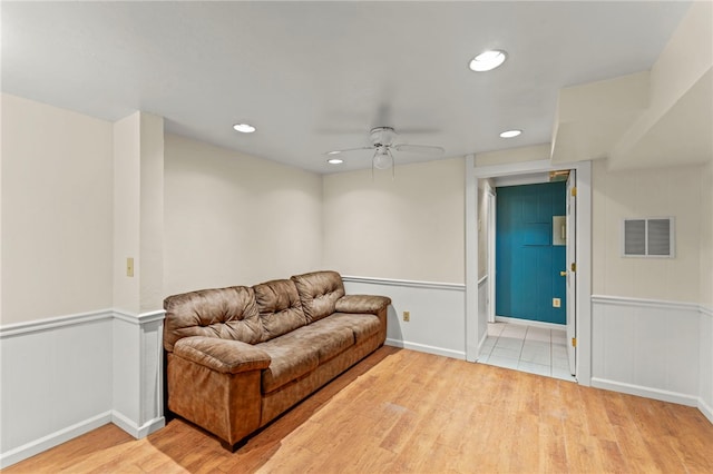 living area featuring light hardwood / wood-style flooring and ceiling fan