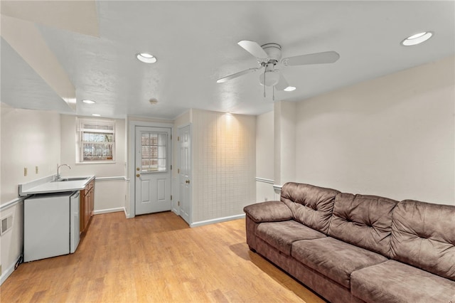 living room with sink, ceiling fan, and light hardwood / wood-style floors