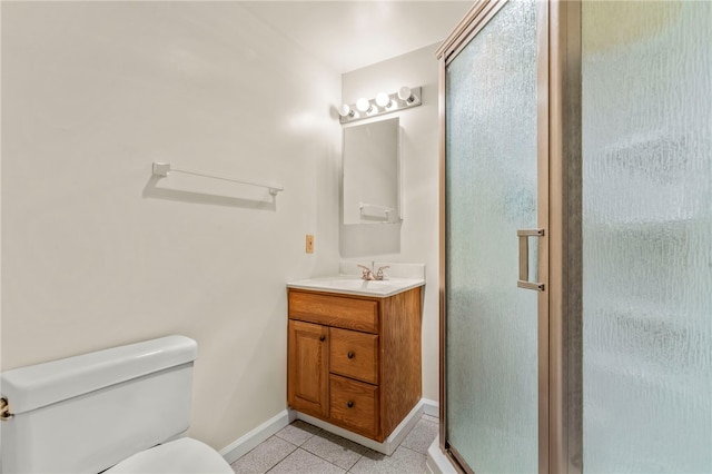 bathroom with vanity, toilet, tile patterned floors, and a shower with door