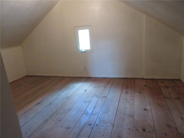 bonus room with lofted ceiling and light wood-type flooring