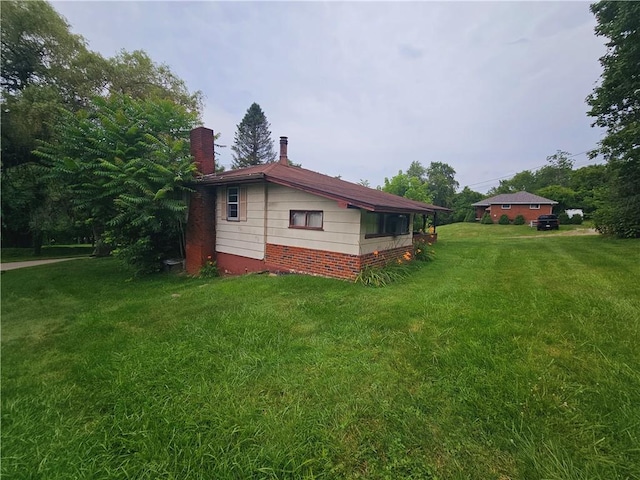 view of side of home with a yard