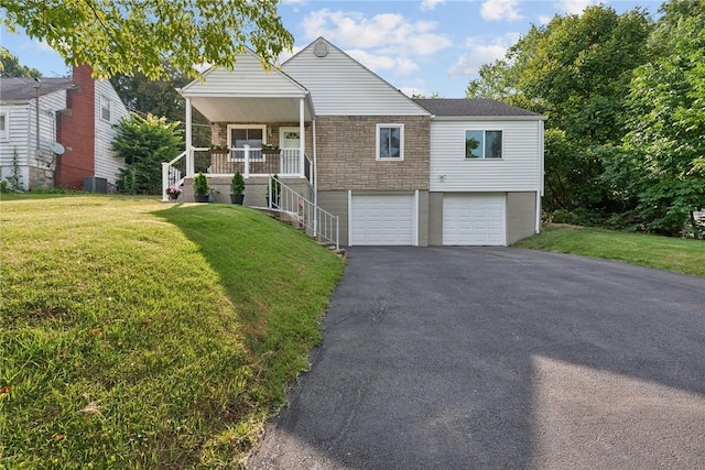 view of front of home with a front yard, a porch, and a garage