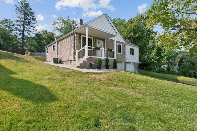 view of front facade with a porch, cooling unit, a front yard, and a garage