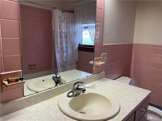 full bathroom featuring vanity, shower / bath combo with shower curtain, tile walls, and toilet