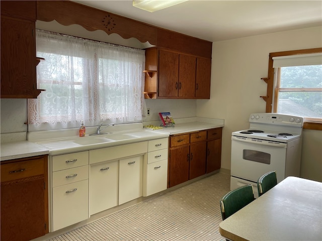 kitchen featuring sink, electric stove, and light tile patterned floors