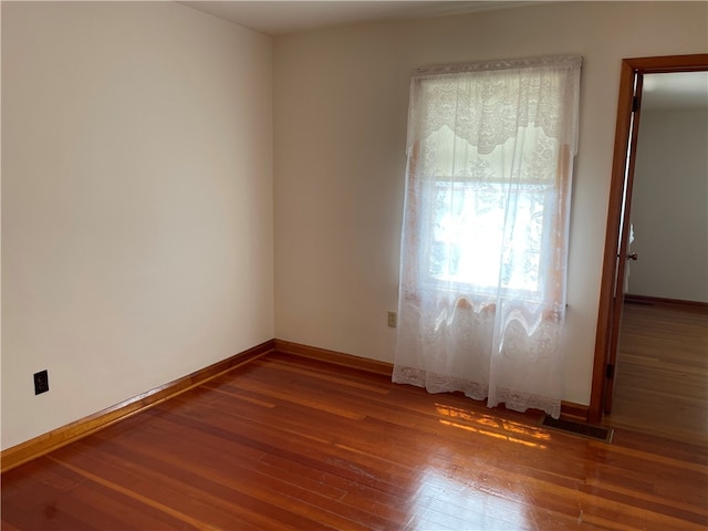 unfurnished room with hardwood / wood-style flooring