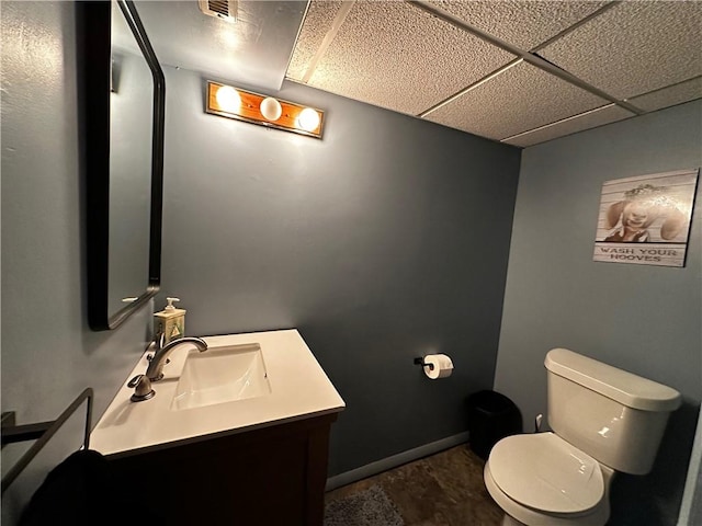 bathroom featuring vanity, a paneled ceiling, and toilet