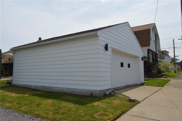 view of side of property featuring an outbuilding, a yard, and a garage