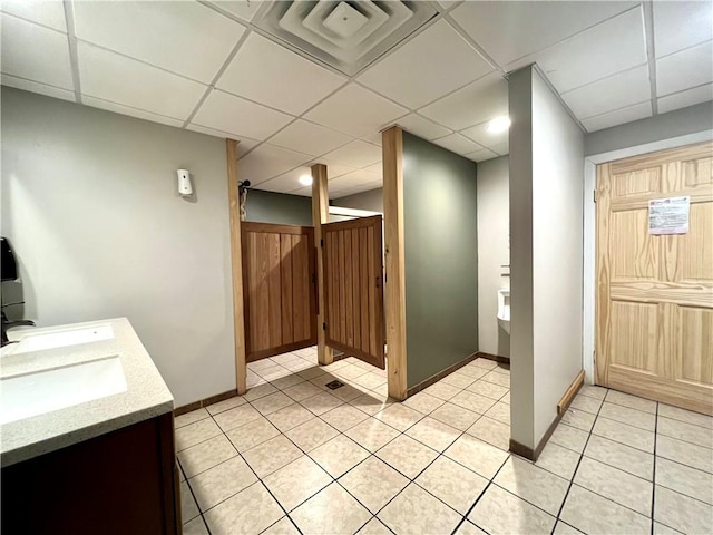 bathroom with vanity, a paneled ceiling, and tile patterned floors