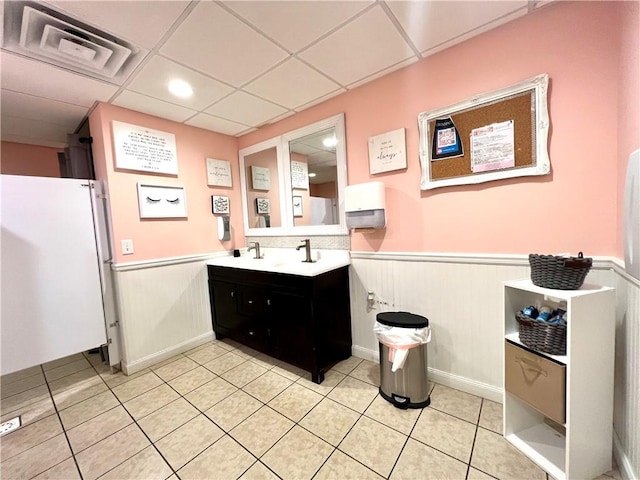 bathroom with vanity, a paneled ceiling, and wood walls