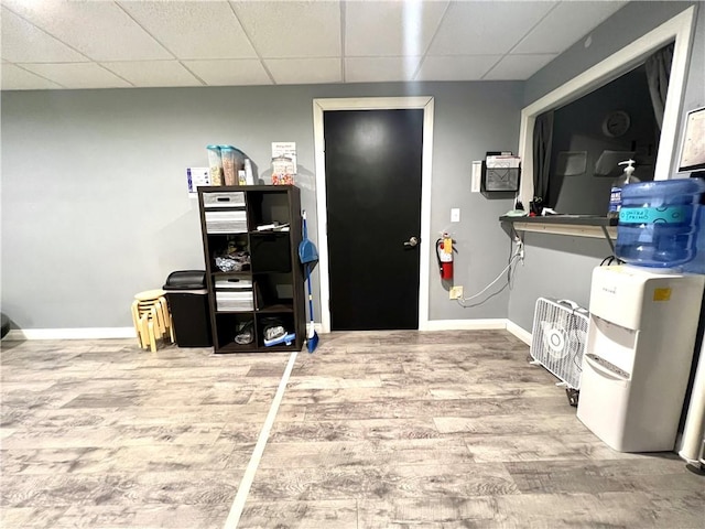 home office with a drop ceiling and wood-type flooring