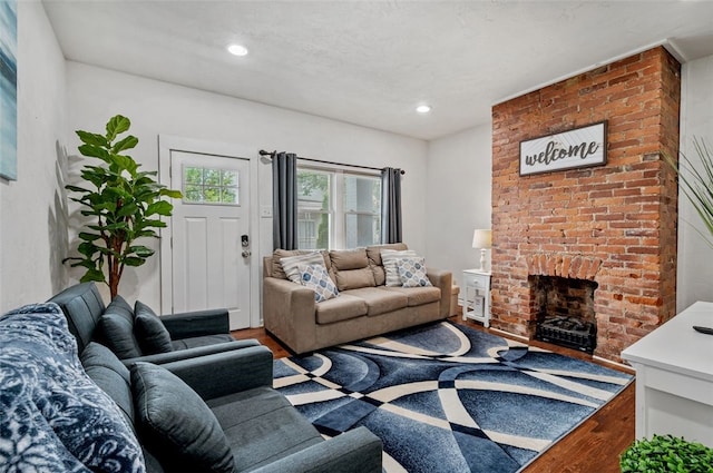 living room featuring a fireplace, recessed lighting, and wood finished floors