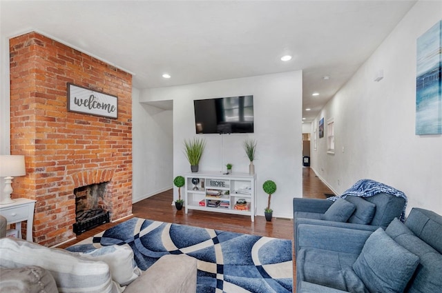 living area with recessed lighting, a brick fireplace, baseboards, and wood finished floors