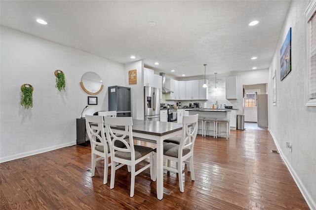 dining area with recessed lighting, baseboards, and dark wood-type flooring