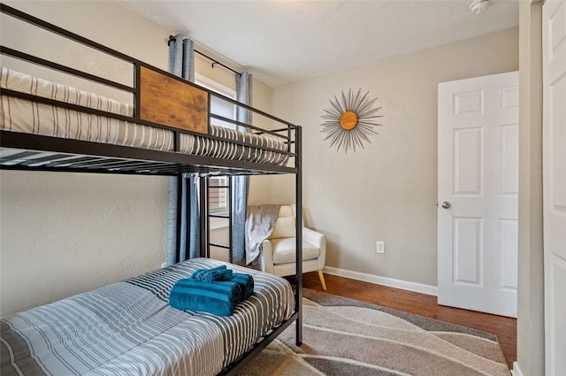 bedroom with baseboards and wood finished floors