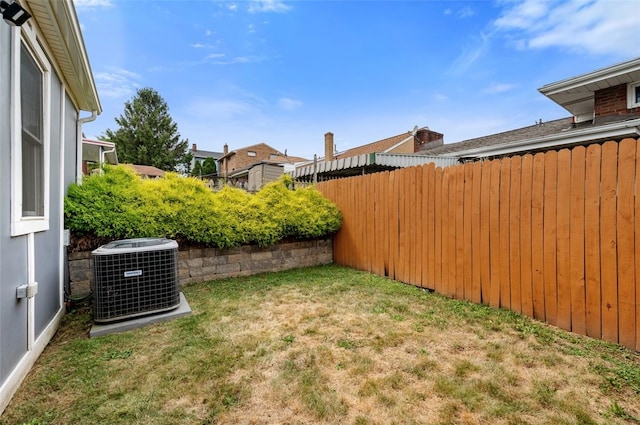 view of yard featuring central AC and fence