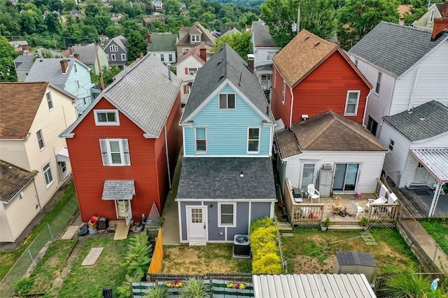 back of property featuring a residential view, central air condition unit, fence private yard, and roof with shingles