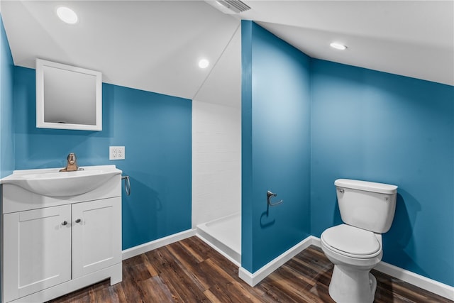 bathroom featuring wood-type flooring, a shower, toilet, and vanity