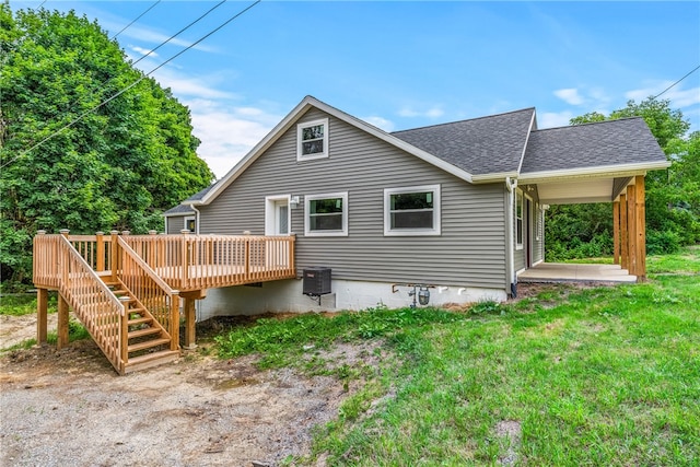 rear view of property with a deck and a lawn