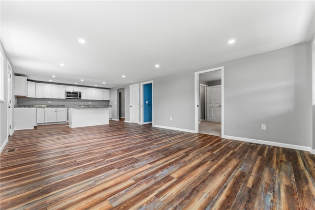 unfurnished living room with dark hardwood / wood-style floors