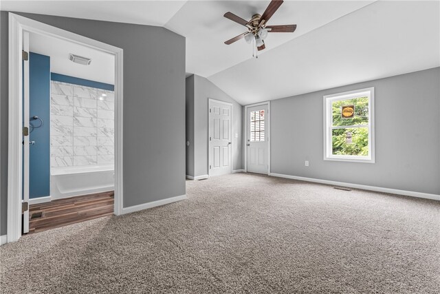 carpeted empty room featuring vaulted ceiling and ceiling fan