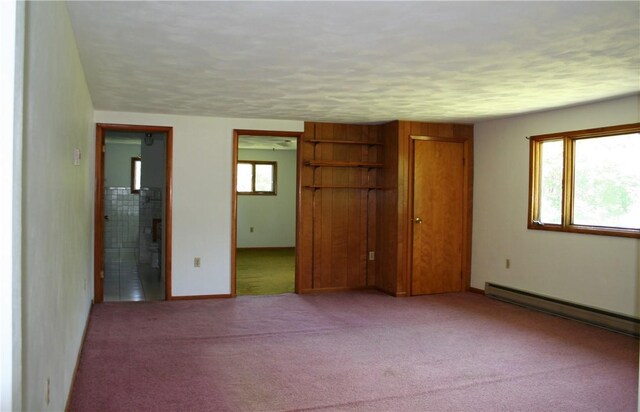 unfurnished bedroom featuring light carpet, a baseboard radiator, and multiple windows